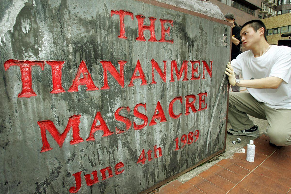 A Hong Kong University student cleans a plaque below the "The Pillar of Shame," a monument constructed to honor the dead and shame the Chinese government that refused to apologize for the Tiananmen Square massacre, which killed students on June 4, 1989 in Beijing's Tiananmen Square. (Mike Clarke/AFP/Getty Images)