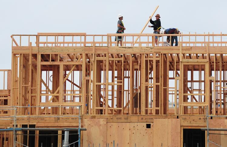Construction workers are seen atop a new apartment building in Alhambra, east of downtown Los Angeles. (Frederic J. Brown/AFP/Getty Images)