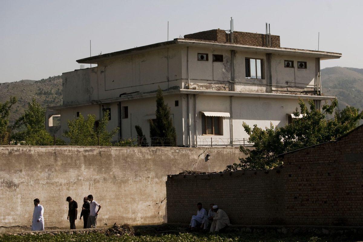 People walk past Osama Bin Laden's compound, where he was killed during a raid by U.S. special forces, Abbottabad, Pakistan, on May 3, 2011. (Getty Images)