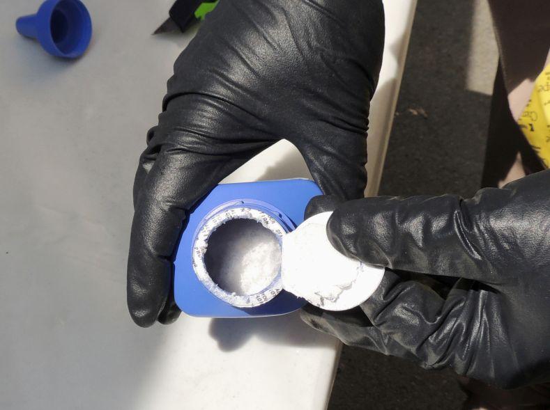 An officer opens a printer ink bottle containing the opioid carfentanil imported from China, in Vancouver, Canada, on June 27, 2016. Drug dealers have been cutting carfentanil and its weaker cousin, fentanyl, into heroin to boost profit margins. (Royal Canadian Mounted Police via AP)