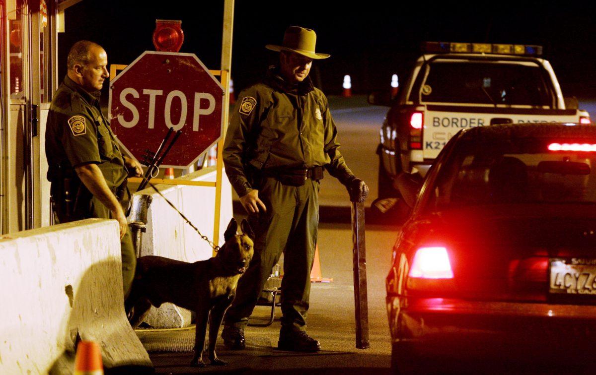 Customs and Border Patrol agents prepare to question a motorist at a checkpoint in Campo, Calif., in an undated photo. A fast-growing wildfire that started Monday in Campo consumed less than a square mile but caused evacuations in the border town.  (Sandy Huffaker/Getty Images)