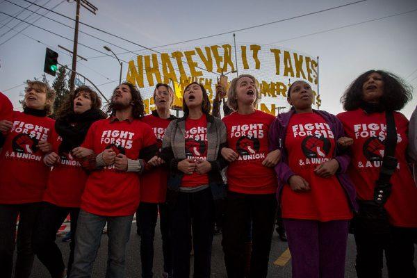 Striking McDonald's restaurant employees lock arms in an intersection before being arrested, after walking off the job to demand a $15 per hour wage and union rights during nationwide 'Fight for $15 Day of Disruption' protests in Los Angeles on Nov. 29, 2016. (David McNew/Getty Images)