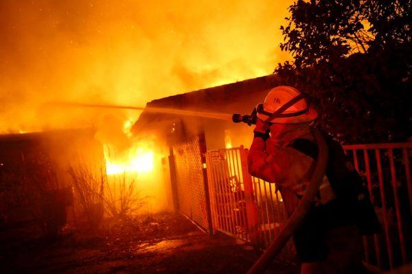 Firefighters try to contain a fire so it doesn't spread to a neighboring building as the Camp Fire moves through the area in Paradise, Calif., on Nov. 8, 2018. (Justin Sullivan/Getty Images)