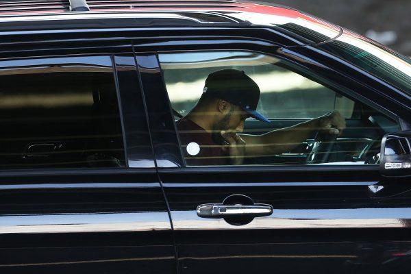 A driver looks down while behind the wheel of a car in New York City on April 30, 2016. (Photo by Spencer Platt/Getty Images)