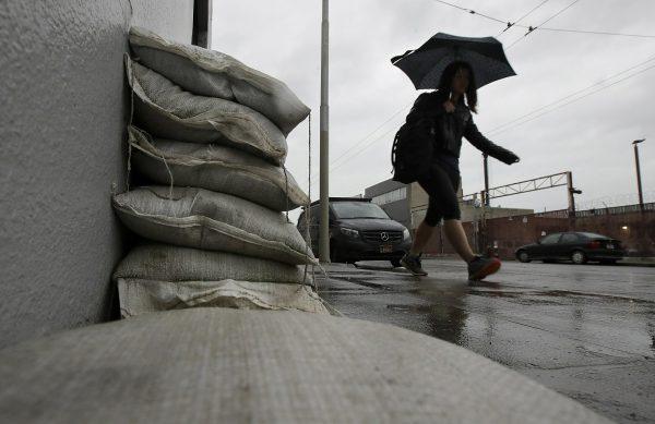 A woman walks past sandbags blocking an entry to a business in San Francisco, on Feb. 1, 2019. (Jeff Chiu/AP Photo)