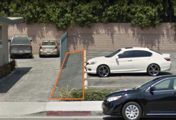 4-feet wide, from the fence on the left to the parking lot on the right, and 96-feet long, from the wall to the sidewalk, this is a narrow strip of land for sale. (Google Maps)