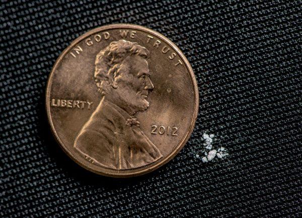 A fatal dose of fentanyl displayed next to a penny. (DEA)