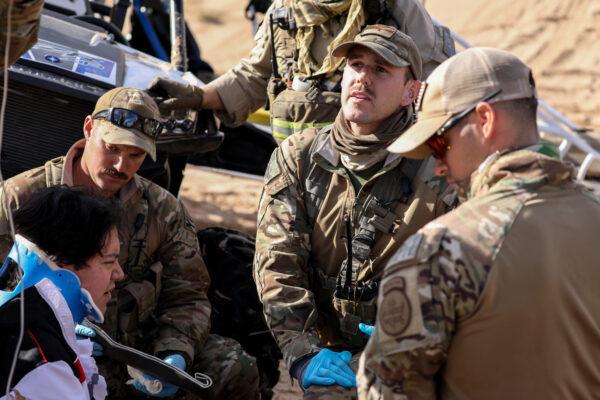 L-R: Border Patrol BORSTAR agents Gary Wegener, Travis Carter, and Eric Carrillo tend to an injured man who crashed his Polaris RZR sand car in the Imperial Sand Dunes near the U.S.–Mexico border, Calif., on Nov. 30, 2019. (Charlotte Cuthbertson/The Epoch Times)