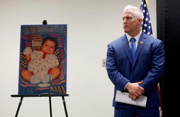 Yolo County District Attorney Jeff Reisig stands next to a photo of one of five infants believed to be killed by their father during a news conference in Woodland, Calif., on Jan. 27, 2020. (Rich Pedroncelli/AP Photo)