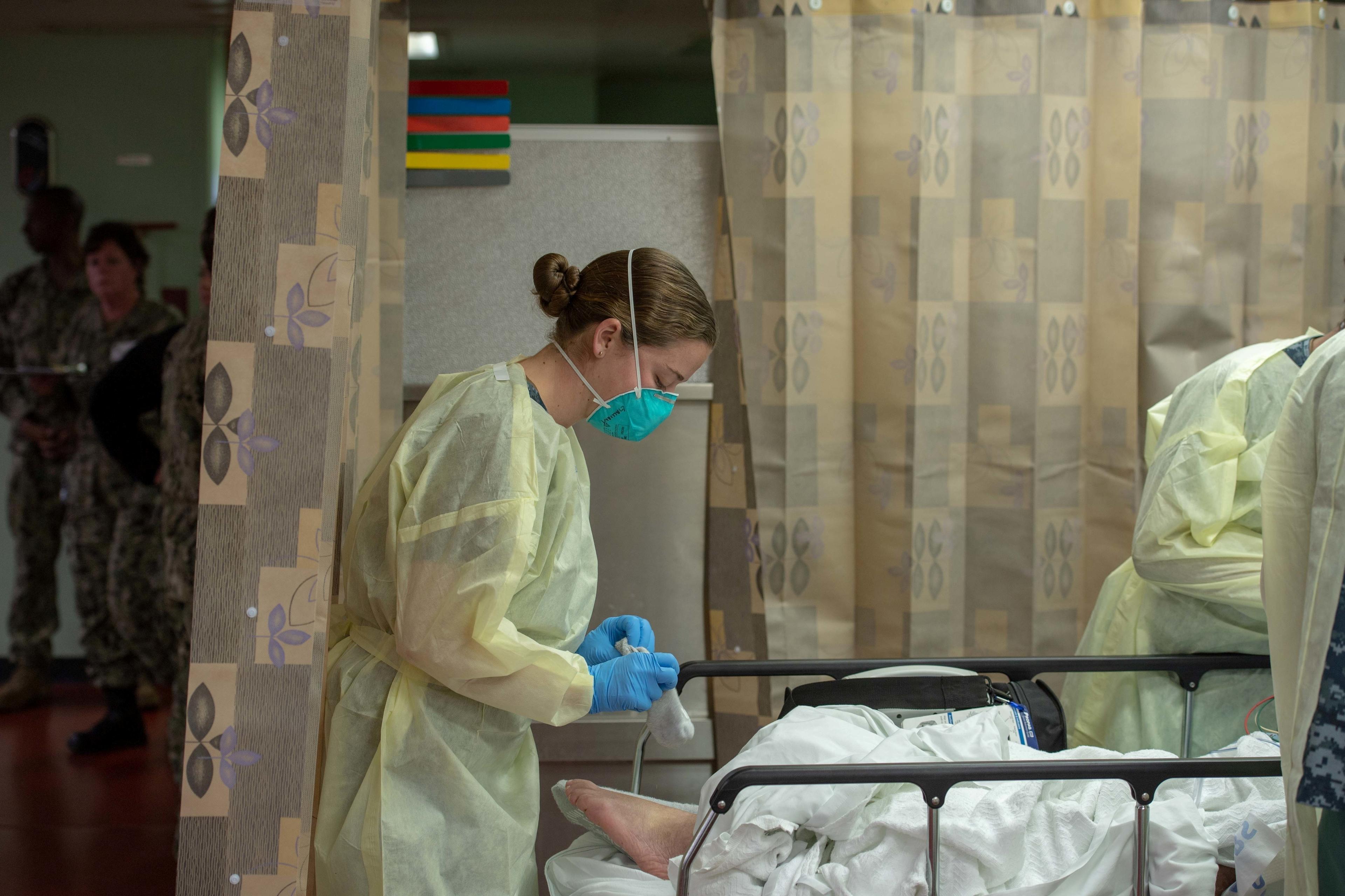 A sailor treats a patient aboard the hospital ship USNS Mercy, which was deployed to serve as a referral hospital for non-CCP virus patients currently admitted to shore-based hospitals, in Los Angeles, California, on March 29, 2020. (U.S. Navy/Mass Communication Specialist 2nd Class Erwin Jacob Miciano/Handout via Reuters)