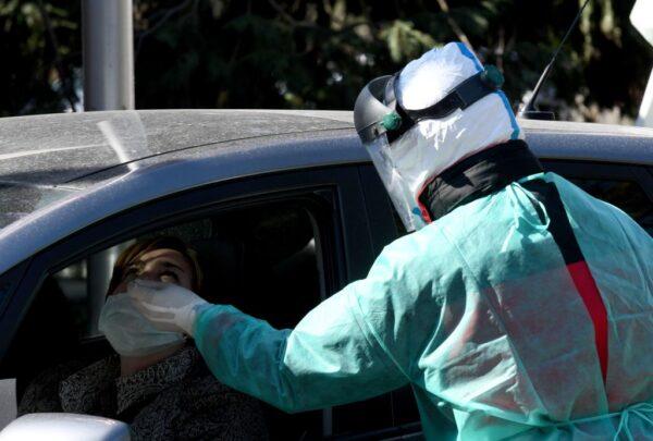 A medical staff member takes nasal swab samples at a drive-through COVID-19 testing point in Zagreb, Croatia, on April 1, 2020. (Denis Lovrovic/AFP via Getty Images)
