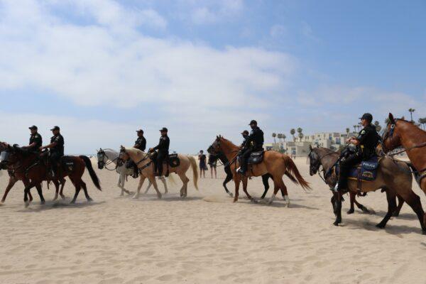Police keep watch over protests in Huntington Beach, Calif., on May 9, 2020. (Jamie Joseph/The Epoch Times)
