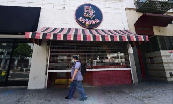 A pedestrian wears a mask while walking past a closed Nickel Diner in Los Angeles on May 7, 2020. (Frederic J. Brown/AFP via Getty Images)