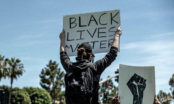 A protester holds a sign at a demonstration in Irvine, Calif., on May 31, 2020, following the death of George Floyd in Minnesota. (Daniel Han)