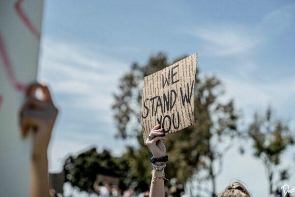 Demonstrators hold their hands up while they kneel on the street in Irvine, Calif., on June 1, 2020, during a protest over the death of George Floyd. (Daniel Han)