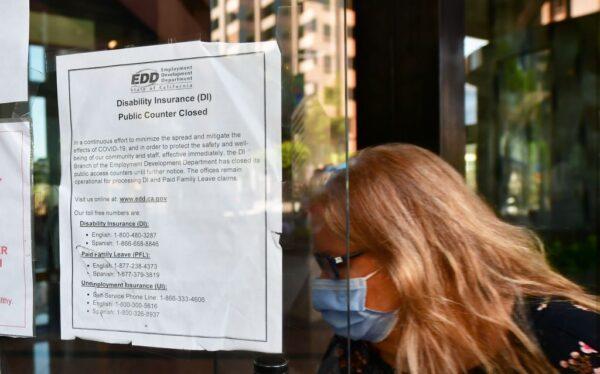 A woman wears a mask as she enters a building where the Employment Development Department (EDD) has its offices in Los Angeles, on May 4, 2020. (Frederic J. Brown/AFP via Getty Images)