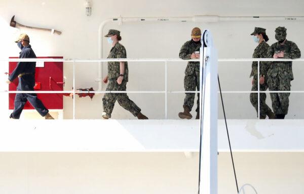 Military personnel walk wearing face masks aboard the USNS Mercy Navy hospital ship docked in the Port of Los Angeles amid the COVID-19 pandemic in San Pedro, Calif., on April 15, 2020. (Mario Tama/Getty Images)
