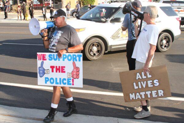 Local residents hold signs with messages responding to the Black Lives Matter protest in Yucaipa, Calif., on Aug. 1, 2020. (Brad Jones/The Epoch Times)