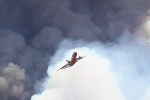 An aircraft, part of firefighting efforts, flies above the Apple Fire, in California's Cherry Valley, on Aug. 1, 2020. (Brad Jones)
