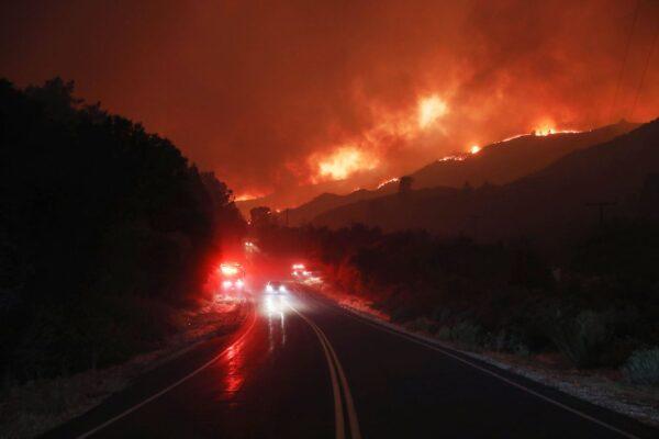 Flames from the Lake Fire burn near fire trucks and other vehicles in Lake Hughes, Calif., on Aug. 12, 2020. (Mario Tama/Getty Images)