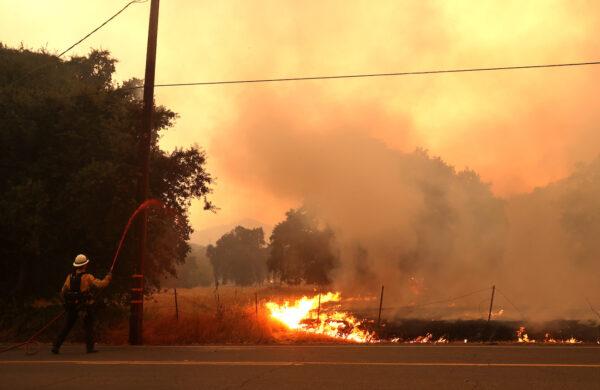 A firefighter sprays retardant on a utility pole as the LNU Lightning Complex fire burns in Fairfield, California, on Aug. 19, 2020. (Justin Sullivan/Getty Images)