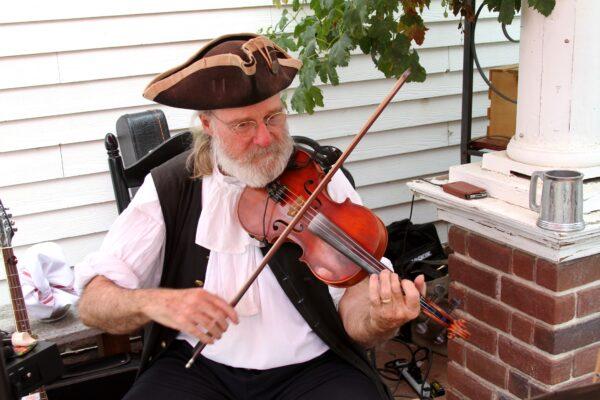 A fiddler in period dress plays at Riley's Farm on the day of the Freedom Protest Rally at Riley's Farm in Oak Glen, Calif., on Aug. 15, 2020. (Brad Jones/The Epoch Times)