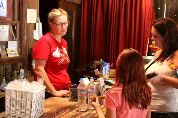 A worker at a shop on Riley's Farm in Oak Glen, Calif., helps customers on Aug. 15, 2020. (Brad Jones/The Epoch Times)
