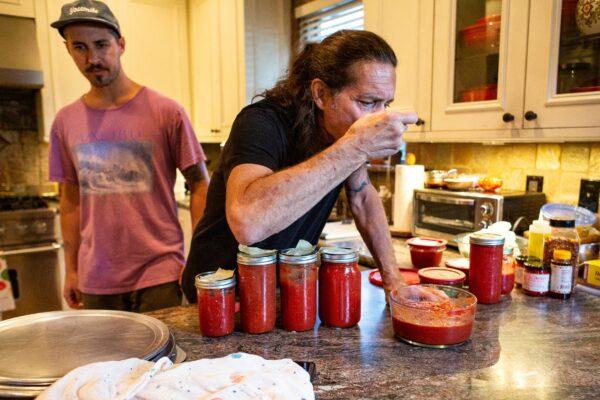 Gene Pietrini taste-tests some pizza sauce in his kitchen in Seal Beach, Calif., on Sept. 19, 2020. (John Fredricks/The Epoch Times)