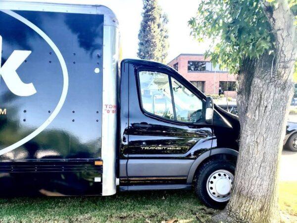 A stolen Geek Squad truck is seen after crashing into a tree and a building in Santa Ana, Calif., on Sept. 24, 2020. (Courtesy of CHP–Santa Ana)