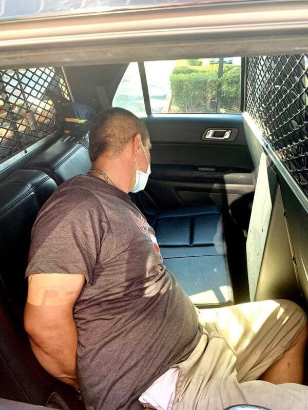 An unidentified suspect is placed into a police vehicle after being arrested for stealing a Geek Squad truck and crashing it into a tree in Santa Ana, Calif., on Sept. 24, 2020. (Courtesy of CHP–Santa Ana)