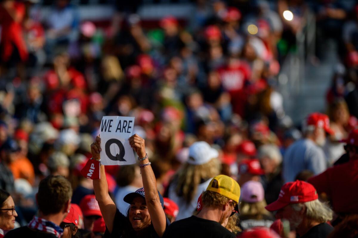 A supporter holds up a QAnon sign to the media as attendees wait for President Donald Trump to speak at a campaign rally at Atlantic Aviation in Moon Township, Pa., on Sept. 22, 2020. (Jeff Swensen/Getty Images)