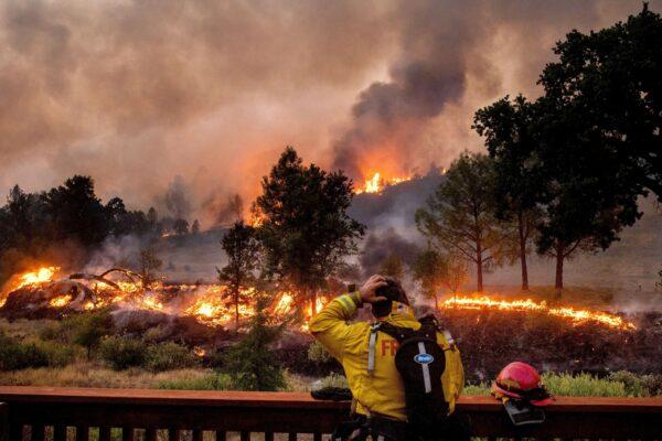 A firefighter rubs his head while watching the LNU Lightning Complex fires spread through the Berryessa Estates neighborhood of unincorporated Napa County, Calif., on Aug. 21, 2020. (Noah Berger/AP Photo)