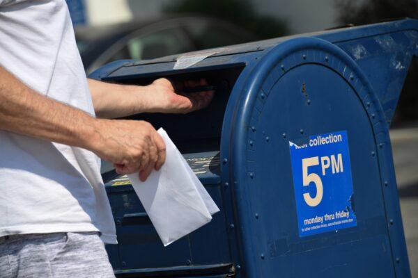 A person mails a letter at a mailbox outside a post office in Los Angeles, Calif., Aug. 17, 2020. (Robyn Beck/AFP via Getty Images)