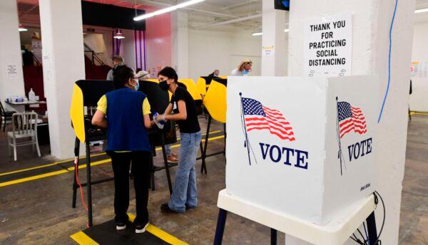 A voter receives assistance from an election worker at a voting center in Grand Central Market in Los Angeles on Nov. 3, 2020. (Frederic J. Brown/AFP via Getty Images)