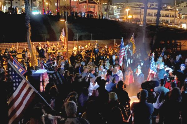 People protesting a new wave of COVID-19 restrictions in California stand around a fire where many of them burned masks in San Clemente, Calif., on Nov. 21, 2020. (Jack Bradley/The Epoch Times)
