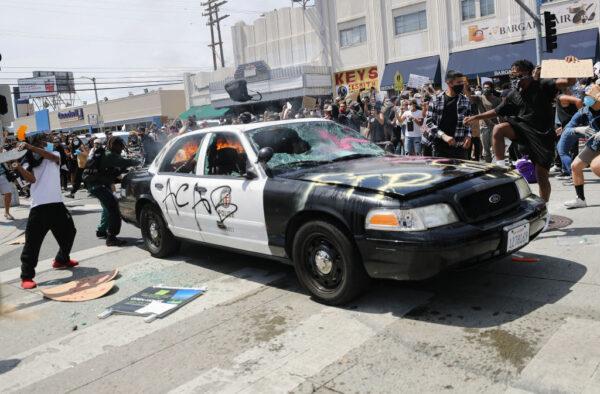 A Los Angeles Police Department vehicle is set on fire by protesters during demonstrations in Los Angeles, on May 30, 2020, following the death of George Floyd. (Mario Tama/Getty Images)