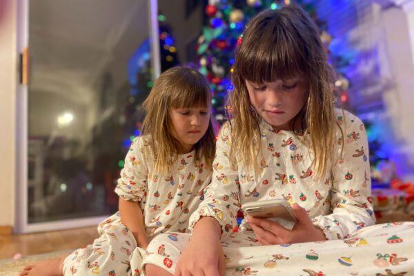 Children talk to Jim Walker, portraying Santa, on Dec. 21, 2020. (Michelle Thompson/The Epoch Times)