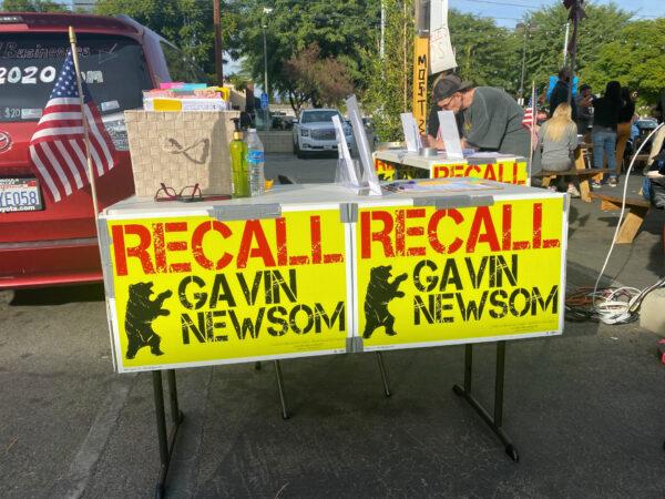 A man looks at items on a table calling for the recall of Gov. Gavin Newsom outside the Pineapple Hill Saloon & Grill in Sherman Oaks, Calif., on Jan. 7, 2021. (Jamie Joseph/The Epoch Times)