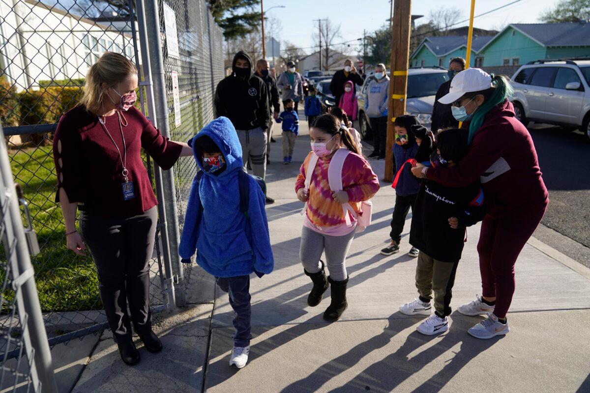 Assistant Principal Janette Van Gelderen, left, welcomes students at Newhall Elementary in Santa Clarita, Calif. on Feb. 25, 2021. (Marcio Jose Sanchez/AP Photo)