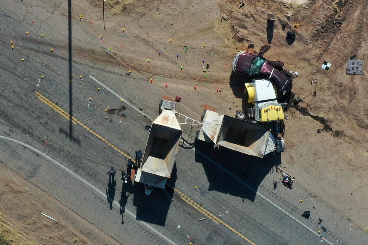 California Highway Patrol officers investigate a crash site after a collision between a Ford Expedition sport utility vehicle and a tractor-trailer truck in Holtville, Calif., on March 2, 2021. (Bing Guan/Reuters)