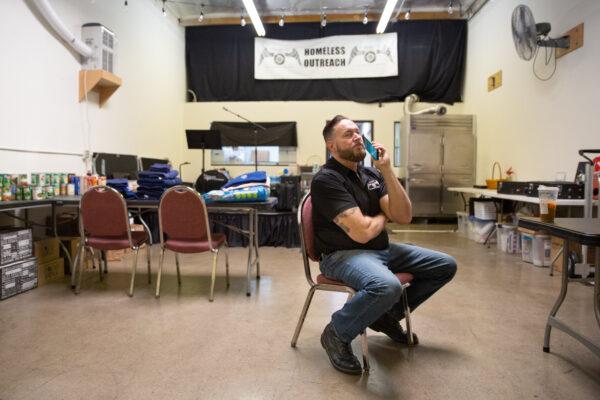 Charity on Wheels Managing Director Zach Southall talks on the phone with a homeless individual in need of help in Anaheim, Calif., on March 5, 2021. (John Fredricks/The Epoch Times)