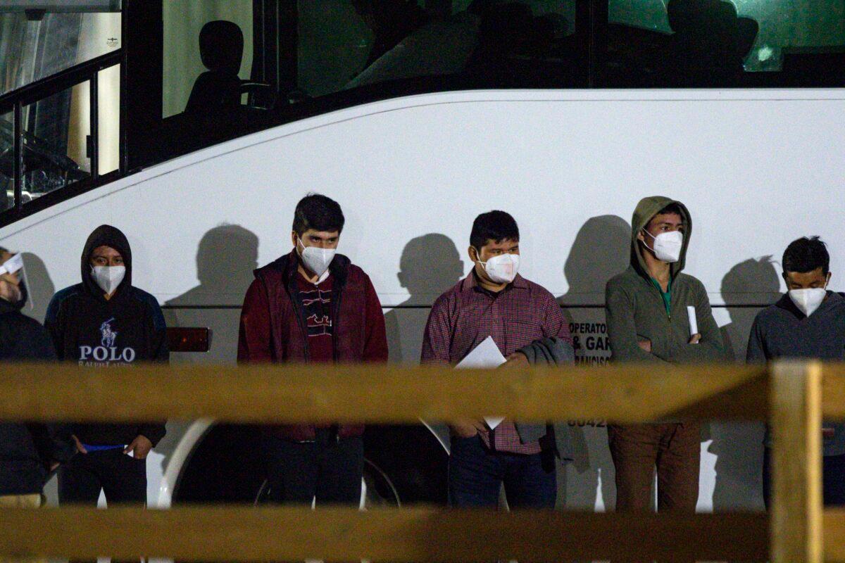 Children and teenagers who illegally crossed the U.S.–Mexico border wait to be processed after entering the site of a temporary holding facility south of Midland, Texas, on March 14, 2021. (Eli Hartman/Odessa American via AP)