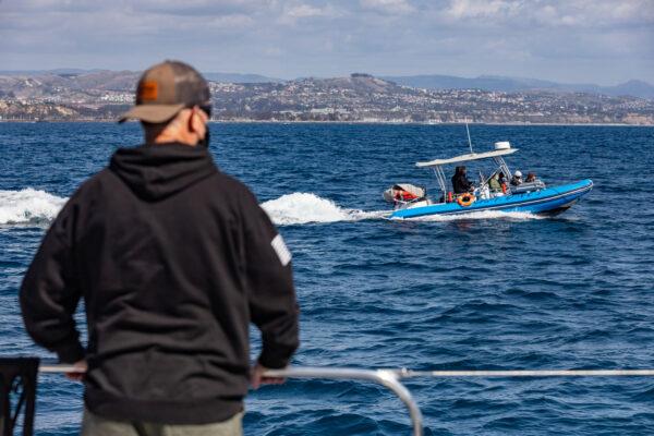 Passengers look on during a whale-watching excursion in Dana Point, Calif., on March 8, 2021. (John Fredricks/The Epoch Times)