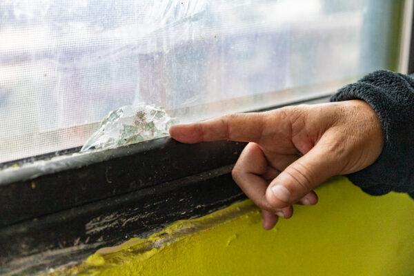 Pastor Albert Rivera points to a bullet hole shot into his church window by drug cartels, in Tijuana, Mexico, on April 22, 2021. (John Fredricks/The Epoch Times)