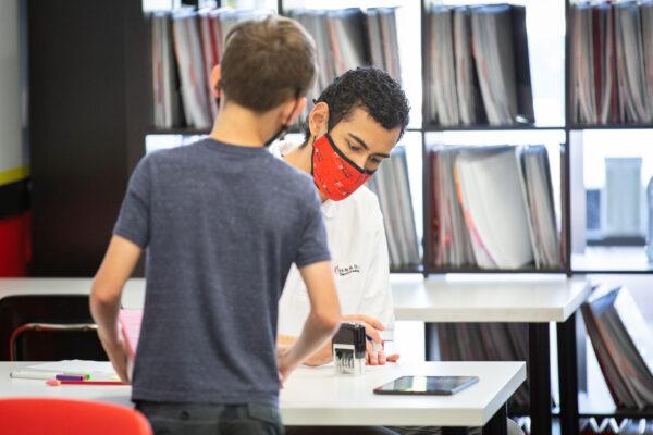 Instructor Arthur Weimholt helps a student perform a math assignment at Mathnasium, in Laguna Niguel, Calif., on May 12, 2021. (John Fredricks/The Epoch Times)