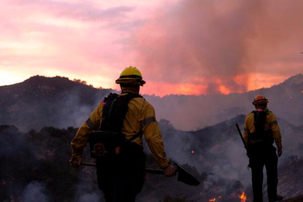Firefighters keep watching as smoke rises from a brush fire scorching at least 100 acres in the Pacific Palisades area of Los Angeles, Calif., on May 15, 2021. (Ringo H.W. Chiu/AP Photo)