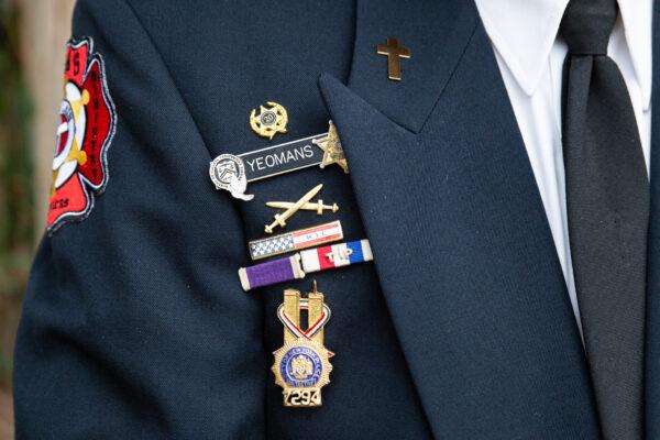 Pastor Richard Yeomans displays pins on his uniform, in San Juan Capistrano, Calif., on May 17, 2021. (John Fredricks/The Epoch Times)