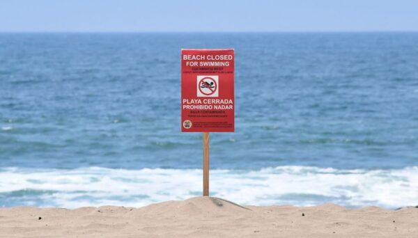 A sign indicating beach closure after a sewage spill in Los Angeles County, Calif., on July 13, 2021. (Frederic J. Brown/AFP Via Getty Images)