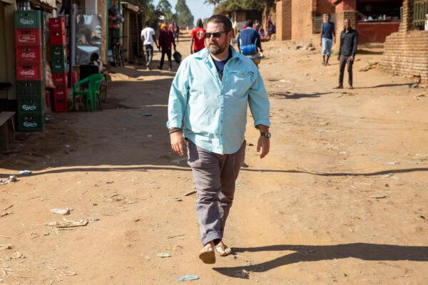 Water Wells for Africa volunteer Ed Fleshman stretches his legs after a long ride one hour north of Blantyre, Malawi, on June 28, 2021. (John Fredricks/The Epoch Times)