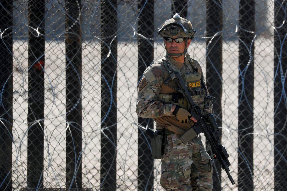 An armed U.S. Customs and Border Patrol agent stands watch at the border fence next to the beach in Tijuana, at the Border State Park in San Diego, Calif., on Nov. 16, 2018. (Mike Blake/File Photo/Reuters)